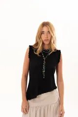 Blusa negra sin mangas con textura arrugada, cuello redondo y detalle de volados en los hombros. Presenta un corte asimétrico en el ruedo.