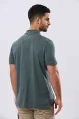 Remera polo de manga corta en color azul melange, con cuello camisero, cierre frontal de dos botones y pequeño bordado en el pecho.
