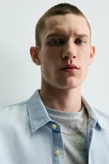 Camisa relaxed fit de denim ligero color celeste, con cuello solapa, manga larga con puños abotonados y cierre frontal de botonadura. Confeccionada con una mezcla de lino y algodón con efecto lavado.