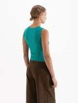 Musculosa de cuello redondo y silueta minimalista, confeccionada en una suave mezcla de poliamida y elastano que ofrece un calce confortable y una gran adaptabilidad al cuerpo. Su diseño sin mangas con hombros sutilmente encajados la convierte en una prenda básica de alta calidad.