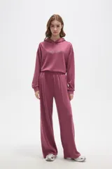 Pantalon de corte ancho y tiro medio, confeccionado en tejido de poliester, con cintura elastizada y costura central vertical en el frente.