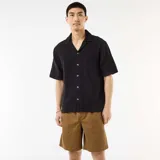 Bermuda estilo chino color marrón, de corte recto y holgado, con bolsillos laterales y trabillas para cinturón.
