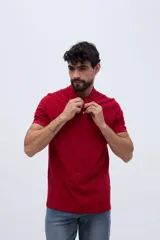Remera polo verde militar de algodón pima, con cuello y puños acanalados, cierre frontal de tres botones y pequeño bordado de ave en el pecho.
