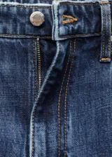 Pantalón de jean tiro medio con corte recto y largo, confeccionado en tejido de algodón. Cuenta con cierre de cremallera y botón, trabillas para cinturón, diseño de cinco bolsillos y aberturas laterales en el bajo.