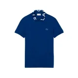 Chomba Lacoste de corte slim fit en color azul, con cuello tipo polo que presenta el nombre de la marca estampado en letras blancas. Incluye el logo del cocodrilo bordado en el pecho.