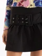 Minifalda negra de microfibra de tiro alto con silueta evasé, con pliegues y frunces bajo la cintura y un cinturón incorporado con hebilla rectangular forrada y ojalillos metálicos.