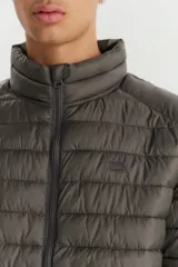Campera puffer de diseño acolchado, color gris oscuro, con cuello alto, cierre frontal completo y bolsillos laterales con cierre.
