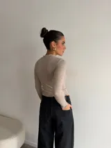 Pantalón de jean negro de tiro alto y corte wide leg, con diseño amplio y dobladillo ancho vuelto hacia arriba.