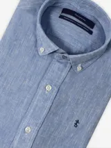 Camisa de lino celeste de manga larga con cuello abotonado y cierre frontal de botones.