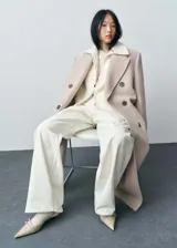 Jeans de corte wide leg en color crudo, con tiro medio, cierre frontal de cremallera, trabillas para cinturón y diseño clásico de cinco bolsillos.