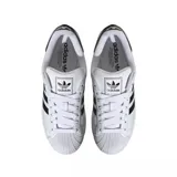 Zapatillas Adidas Superstar blancas con las tres tiras laterales en negro y contrafuerte trasero en cuero negro.