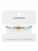 Pulsera dorada con dije central en forma de pez, decorada con perlas, cuentas turquesas y abalorios metálicos.