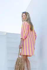 Vestido camisero a rayas verticales fucsias y amarillas, con cuello redondo, cierre frontal de botones y mangas largas abullonadas con puños elásticos.