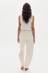 Pantalón de jean color blanco marfil, con tiro medio, corte barrel relajado y bolsillos frontales y traseros.