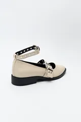 Zuecos de charol color borgoña con punta fina, correa al tobillo y doble tira sobre el empeine con hebillas metálicas plateadas.