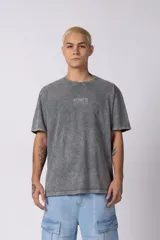 Remera gris de corte oversize con efecto acid wash y estampa pequeña en el pecho.