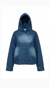 Canguro con capucha de denim azul, con efecto desgastado en el centro del pecho. Presenta un bolsillo canguro frontal y cordones ajustables en el bajo para modificar el calce.