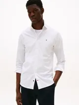 Camisa blanca de manga larga Tommy Hilfiger de corte regular fit, confeccionada en algodón regenerativo, algodón BCI y elastano.