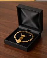Collar de acero con baño de oro, compuesto por una cadena tipo serpiente y un dije vertical formado por tres discos circulares de acabado cepillado.
