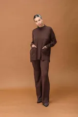 Conjunto de dos piezas tejido en color marrón chocolate, compuesto por un buzo de cuello alto con bolsillos frontales y un pantalón de corte recto y holgado.
