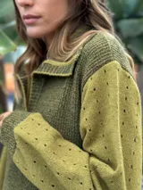 Vestido largo de punto en color verde oliva, con diseño de paneles en dos tonos de verde, mangas largas con textura perforada y tajos laterales en el ruedo.