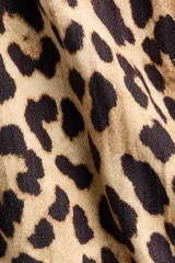 Campera oversized de sarga con estampado de leopardo, cuello camisero, cierre frontal, bolsillos laterales ribeteados y puños elásticos.