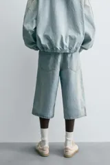 Bermudas de denim de algodón, color celeste claro con efecto vintage y manchas claras en las perneras. Tienen un corte ancho (baggy fit), tiro alto y cinco bolsillos.