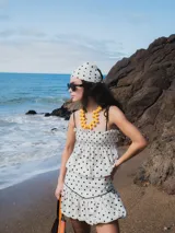 Musculosa blanca con estampado de lunares negros, breteles finos negros y frunce elástico en el busto.