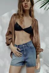 Shorts de denim de tiro medio, corte mom fit, con cinco bolsillos y cierre frontal con cremallera y botón, en color azul lavado.