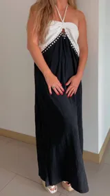 Vestido largo de breteles con parte superior blanca y falda negra. Presenta detalle de tachas plateadas en el borde de la parte superior.