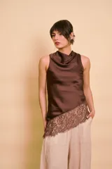 Blusa marrón de satén sin mangas, con cuello drapeado y detalle de encaje en el dobladillo inferior cortado en diagonal.