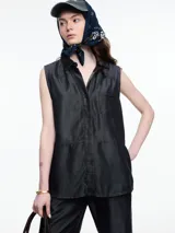 Camisa sin mangas en denim color negro, confeccionada en 100% lyocell. De corte recto y largo medio, presenta cartera escondida en el frente, un bolsillo plaqué en el pecho y botones decorativos alineados en abertura vertical en la espalda.
