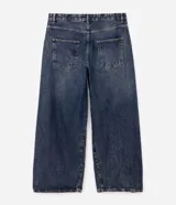 Pantalón de jean con calce barrel, caracterizado por su volumen amplio en las piernas y un sutil ajuste en la botamanga. Presenta costuras desplazadas y un lavado medio, confeccionado en algodón resistente.
