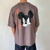 Remera color gris topo de corte oversize con estampa de Mickey Mouse en la espalda y caracteres orientales en color naranja.