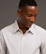 Camisa de vestir para hombre, de manga larga y calce clásico, confeccionada en tricolina de algodón y poliéster, con diseño de cuadros grid en tono celeste claro. Presenta cuello camisero, cierre frontal con botones y puños ajustables con botón único.