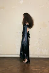 Corset negro con escote strapless, detalle de herradura metálica en el centro y tirantes de cinta de raso que se atan en los hombros. Ajuste con cinta de raso en la espalda.