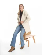 Cardigan de textura tipo corderito, color blanco, con diseño abierto sin botones, capucha amplia y mangas largas con puños de rib elástico. Cuenta con bolsillos delanteros de corte diagonal.