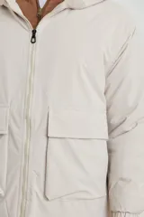 Campera impermeable negra con capucha, cierres a tono y cursores negros metalizados, bolsillos frontales con tapa, elásticos regulables en el ruedo e interior térmico con detalles confeccionados con láser.