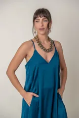 Vestido largo de seda en color azul petróleo, con escote en V, breteles finos y bolsillos laterales. Diseño holgado y fluido.
