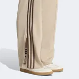 Pantalón deportivo Adidas modelo Firebird de corte holgado y tiro medio. Presenta diseño clásico con las tres rayas características de la marca en los laterales y confeccionado en tejido tricot suave.