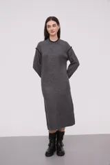 Vestido midi gris de tejido de punto, con cuello redondo y mangas largas. Presenta ribete negro en cuello, puños y hombros.