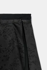 Falda midi de tiro medio en tejido jacquard con diseño floral tono sobre tono. Presenta un corte recto con una abertura lateral y cierre oculto con botón y cremallera.