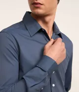 Camisa de vestir masculina corte slim, color azul acero, con cuello inglés, manga larga y cierre frontal con botones. Confeccionada con tecnología Easy Care que aporta elasticidad y secado rápido.