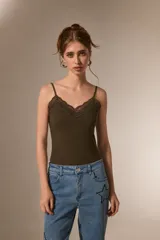 Body de breteles finos con escote en V y detalle de encaje en el borde superior. Diseño ajustado al cuerpo con cierre de broches en la parte inferior.