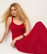 Blusa femenina color rojo, confeccionada en algodón y poliéster con efecto punto. Diseño sin mangas, con breteles anchos, escote en V, modelo ajustado en el busto con recorte horizontal y acabado peplum en el ruedo.