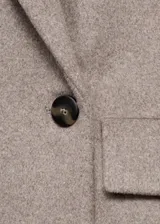 Abrigo midi de corte recto confeccionado en mezcla de lana, con cuello de solapa, cierre frontal de doble botonadura y dos bolsillos laterales con solapa.