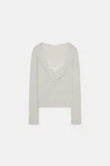 Conjunto de chaqueta de punto de cuello redondo y manga larga con cierre frontal de botones, combinada con un top interior de escote en pico con detalles de encaje.