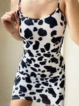 Vestido corto ajustado al cuerpo, con tirantes finos y escote redondo, estampado de manchas de vaca (blanco y negro).