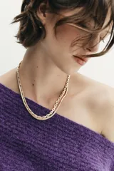 Jersey de punto de textura suave en color violeta, con diseño asimétrico de un solo hombro y manga larga.