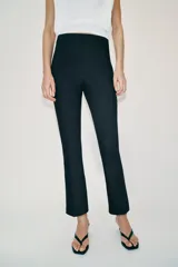 Pantalón de tiro medio con cintura elástica y corte mini flare, acabado en evasé. Cuenta con cierre lateral con cremallera oculta en la costura.